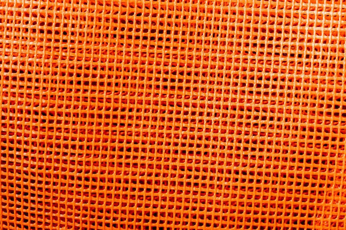 Close-up of rigid orange plastic mesh with a repeating diamond grid pattern, the same category of material used for craft-mesh betta dividers.