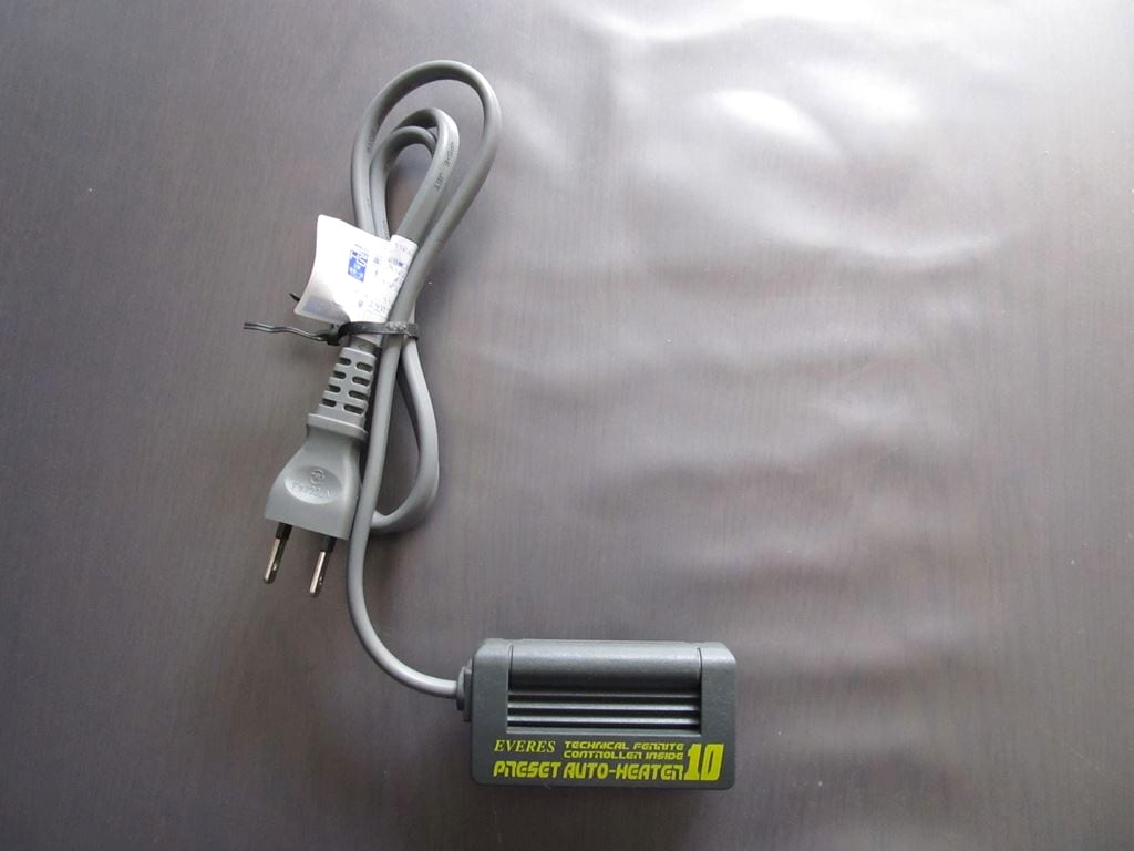 A submersible aquarium heater in a small tank — the equipment that keeps a betta at the 78–82 °F range it requires.